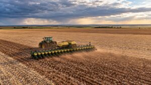 Plantadeira semeando soja em grande lavoura no início das chuvas